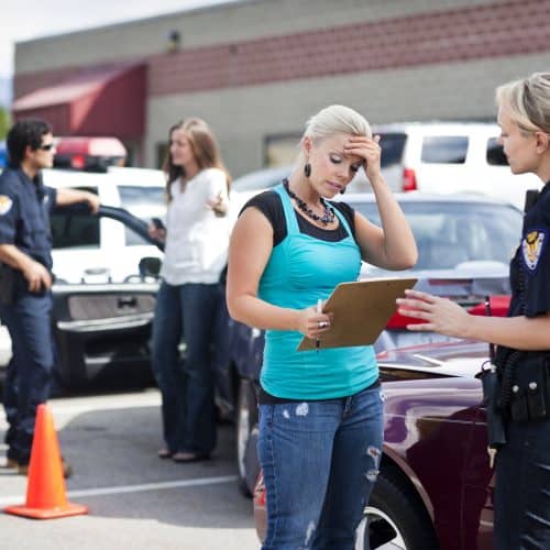 A woman talking to the police after getting into a car accident.