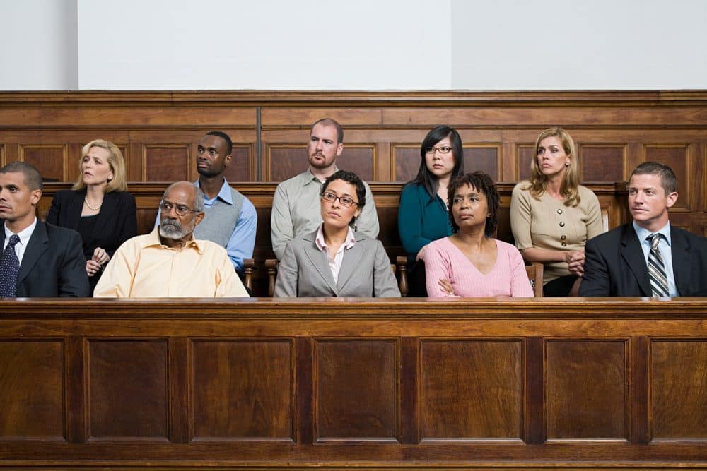 A jury listening to case presentations in a courtroom.