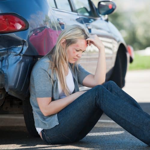 A woman leaning against her car after an accident in Odessa, TX.